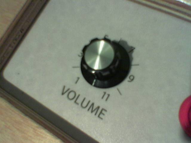 Close-up of a black volume knob on a grey amplifier panel, numbered 1, 3, 5, 7, 9 and 11