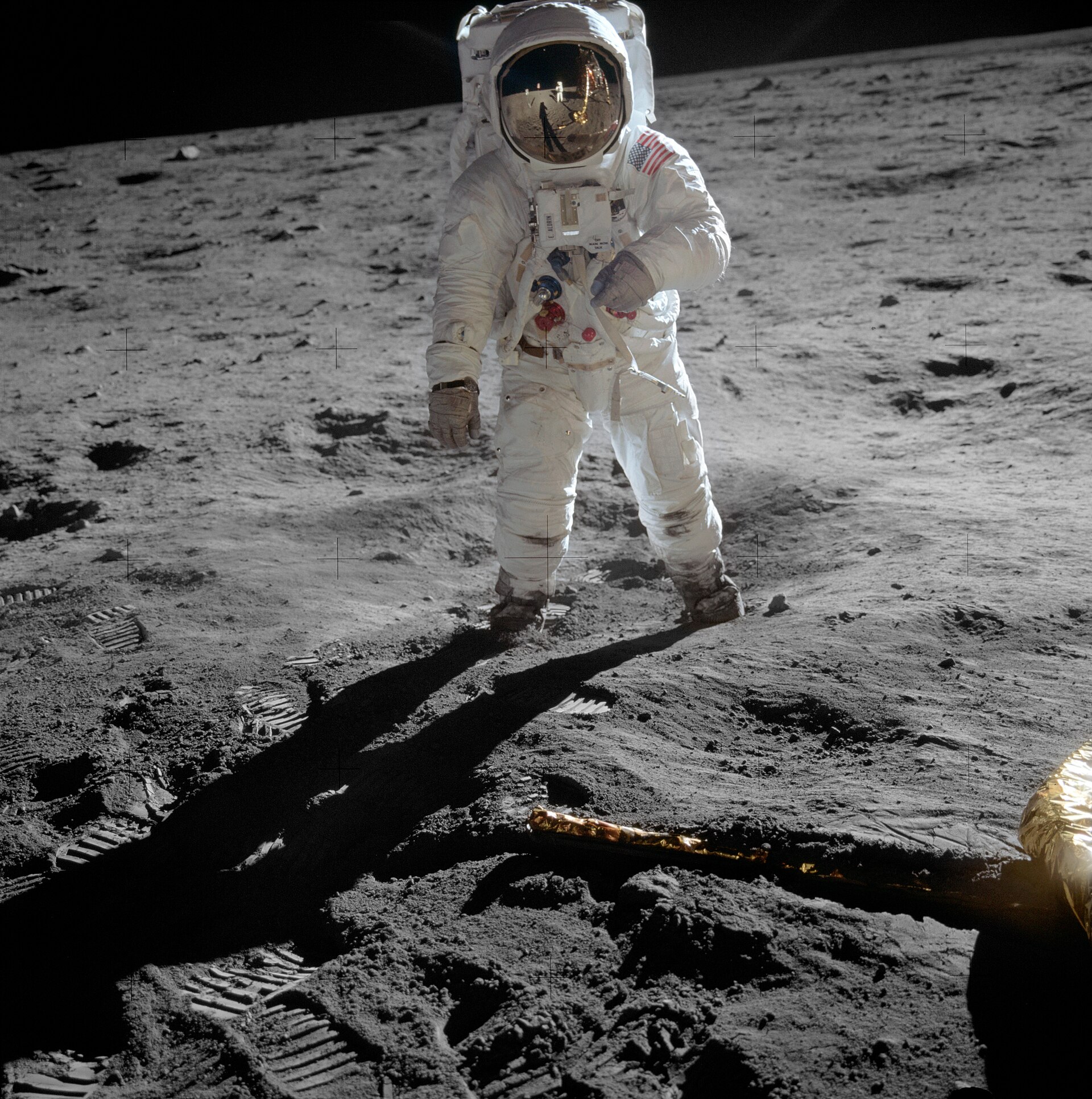 Buzz Aldrin standing on the Moon, with Neil Armstrong and the lunar module reflected in his visor