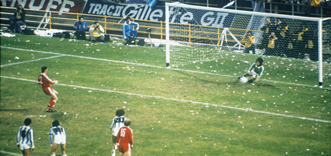 A penalty at the 1978 World Cup: the Argentine goalkeeper dives and stops the ball, the Polish players watch from the edge of the box