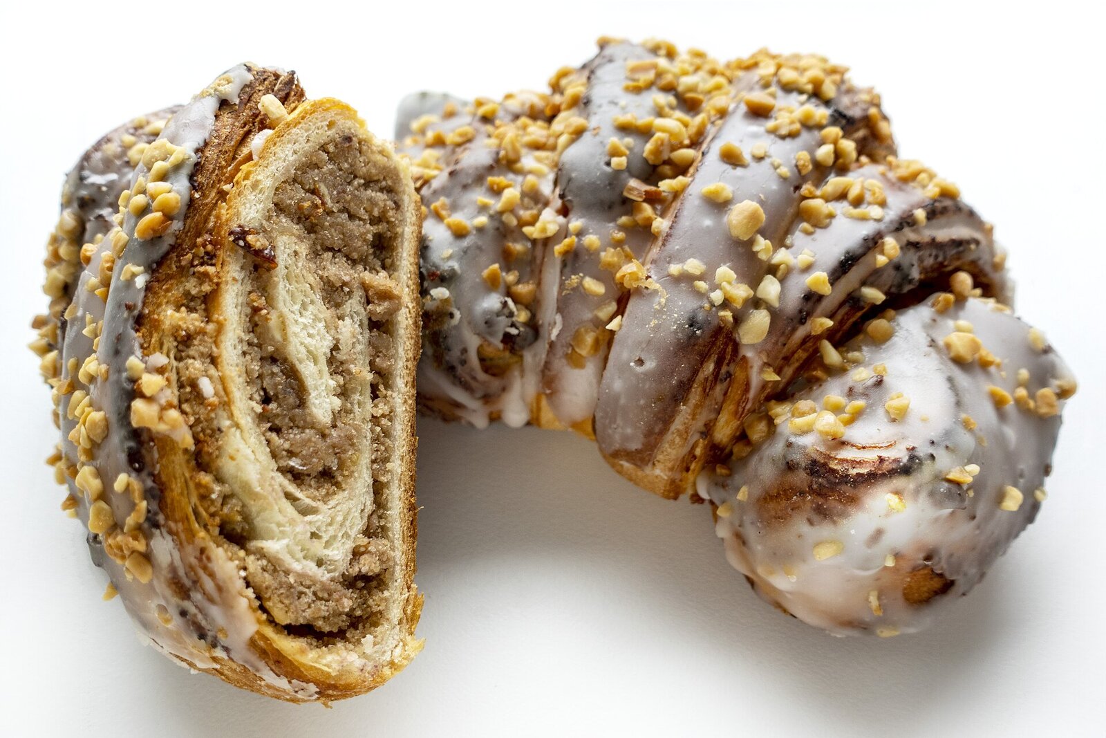A St Martin's croissant cut open: layers of pastry around a thick white-poppy-seed filling, the top covered in white icing and chopped nuts